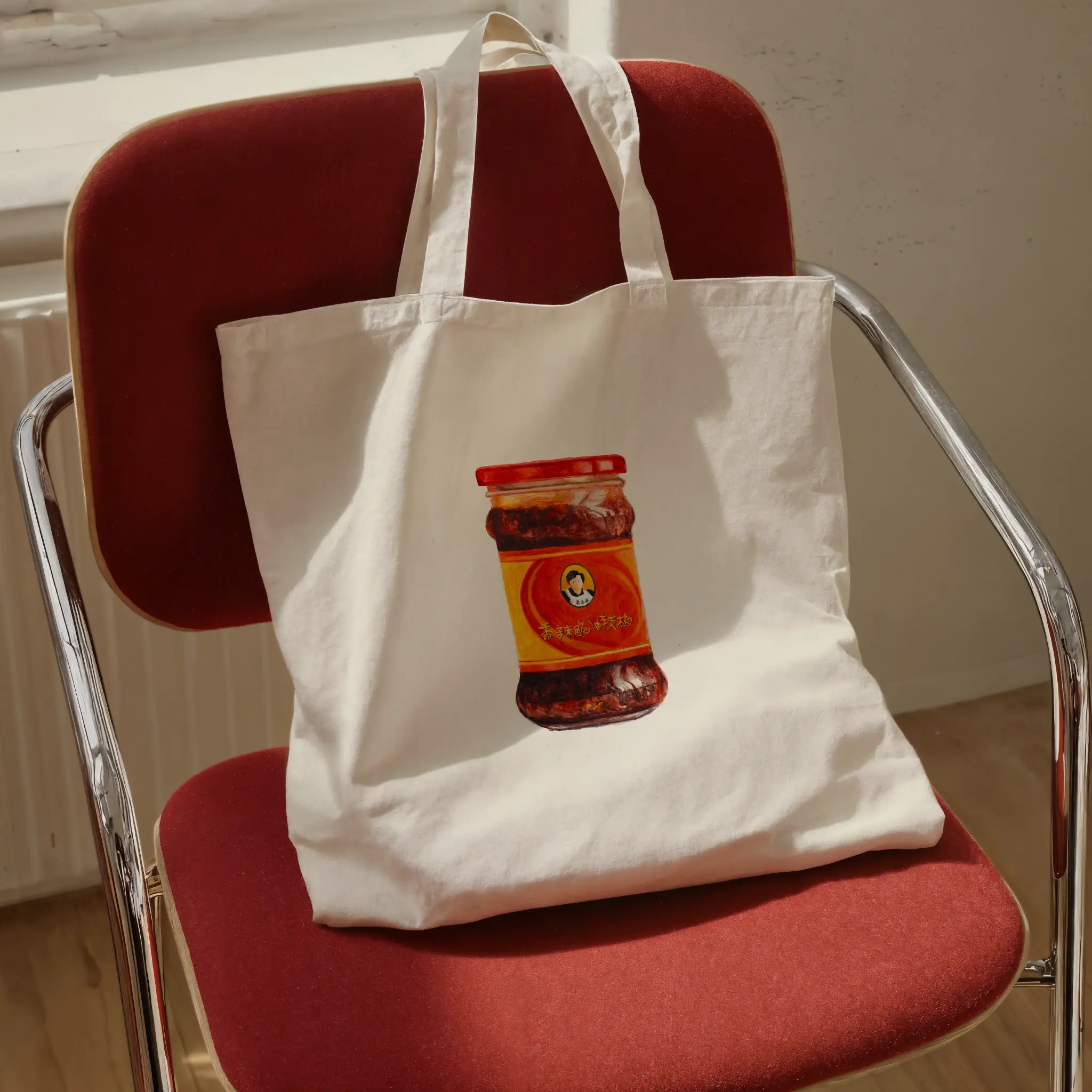 spicy chili crisp cotton tote bag with original watercolor design, shown in a flat lay product view