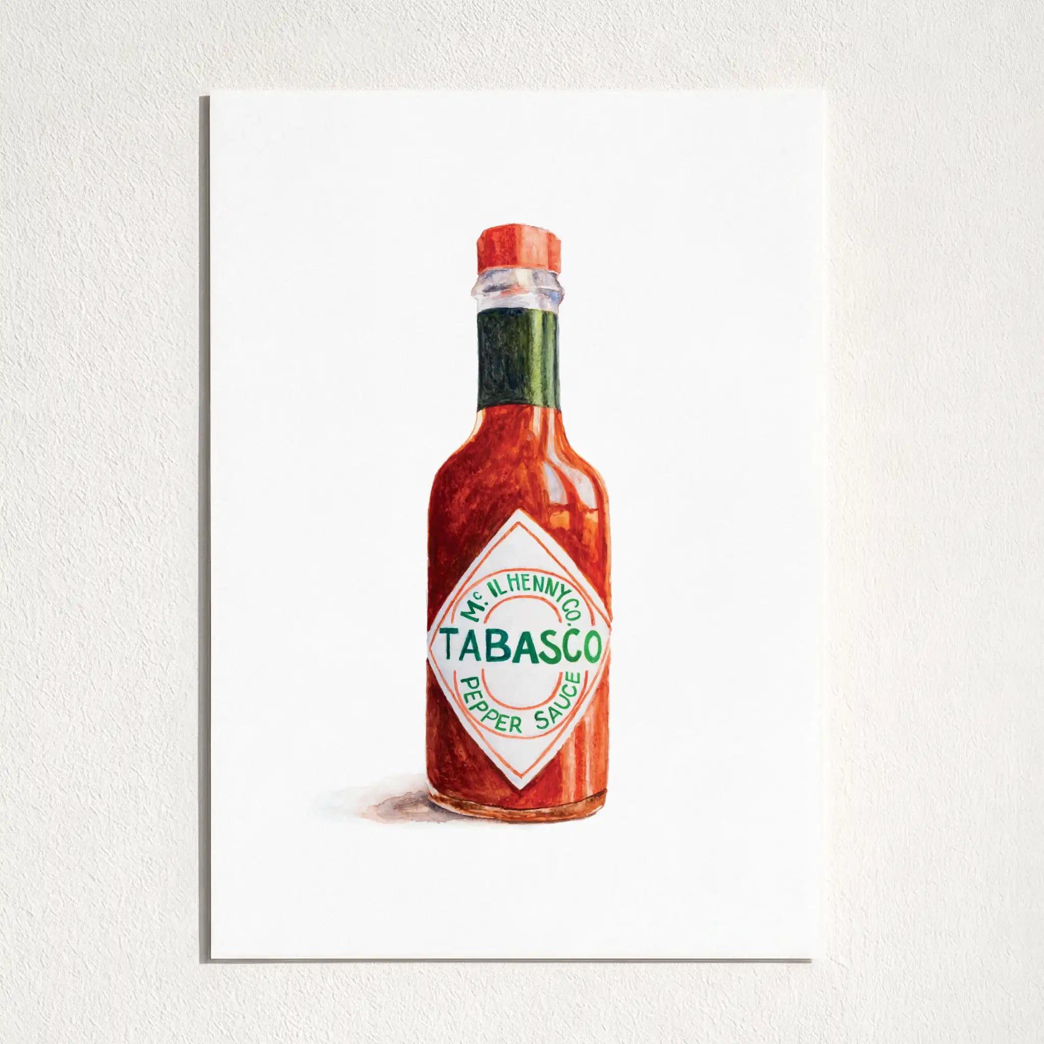 A watercolor art print of a classic Tabasco pepper sauce bottle, displayed on a textured white wall.