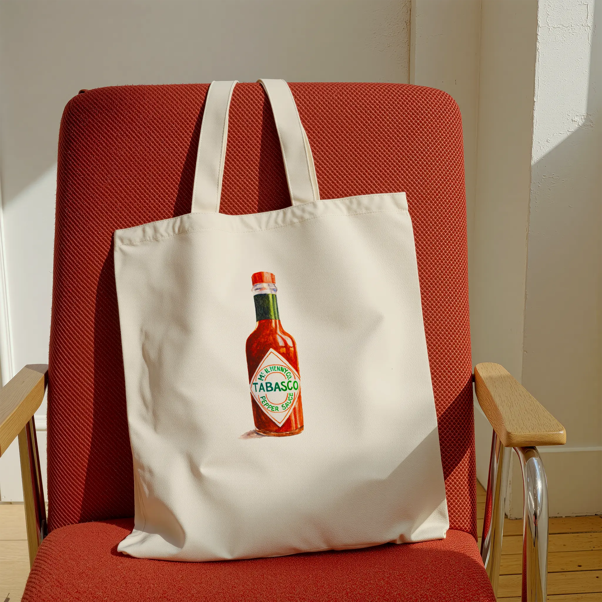 tabasco watercolor illustration cotton tote bag on a red chair in a modern interior
